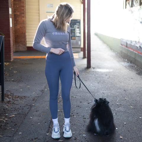 Black Pomeranian dog on a leash near an Emamaco Shaper Move long line crop top.